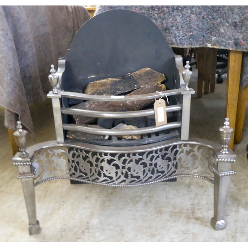 123 - A cast iron and steel fireplace with turned finials, raised on square, tapered feet  27