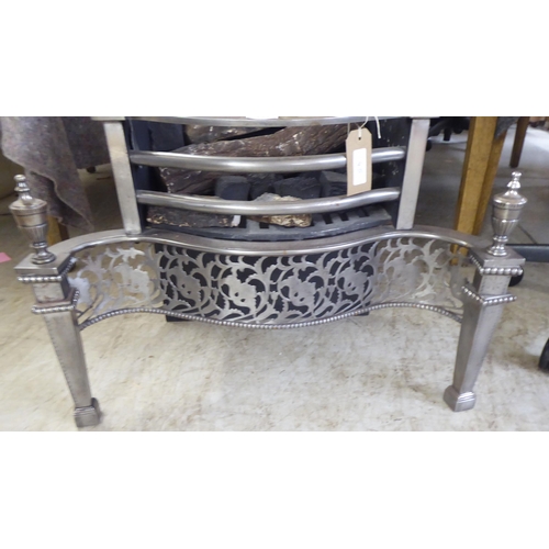 123 - A cast iron and steel fireplace with turned finials, raised on square, tapered feet  27