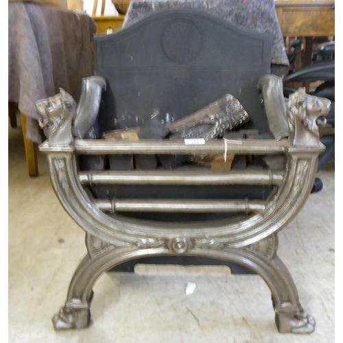 124 - A cast iron and steel fireplace with lion mask finials, raised on paw feet  28