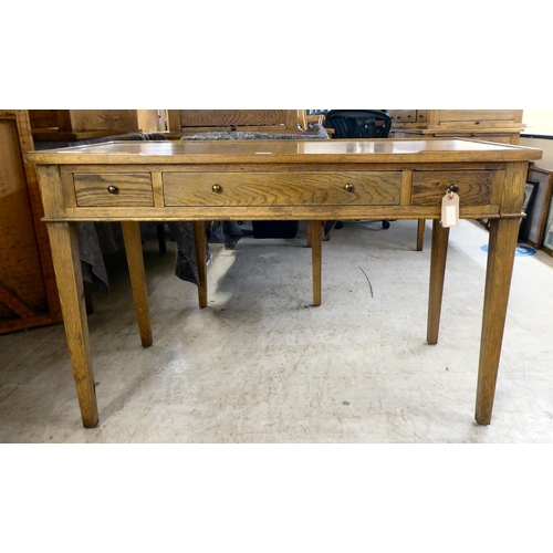 130 - A modern OKA oak desk with three drawers, raised on square, tapered legs  31