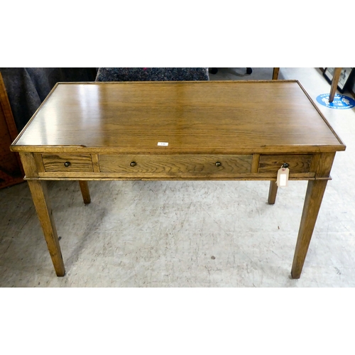 130 - A modern OKA oak desk with three drawers, raised on square, tapered legs  31