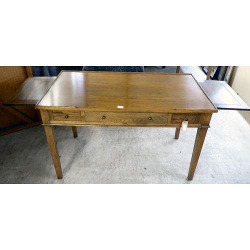 130 - A modern OKA oak desk with three drawers, raised on square, tapered legs  31