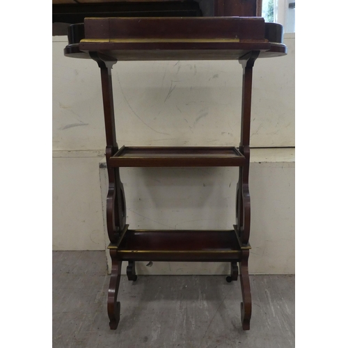 133 - An Edwardian mahogany three tier book stand, raised on arched legs  29