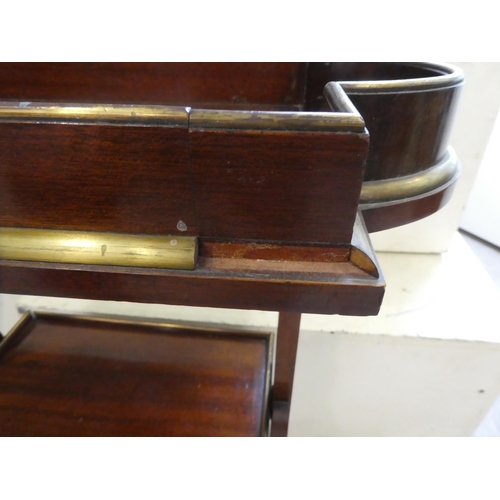 133 - An Edwardian mahogany three tier book stand, raised on arched legs  29