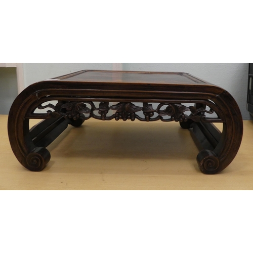 136 - An early 20thC Chinese rosewood ceremonial table with a leaf and berry carved frieze, raised on curv... 