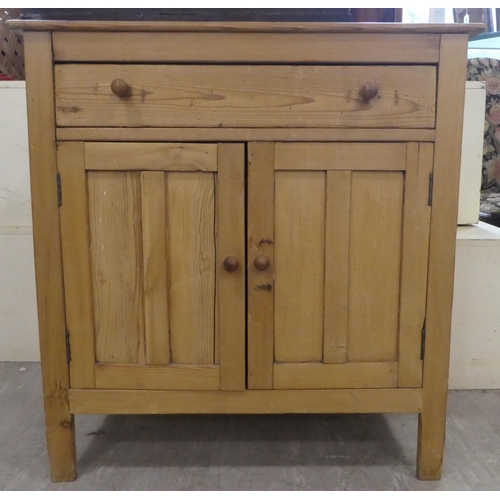 140 - A mid 20thC pine cabinet with two drawers and two doors, raised on block legs  31