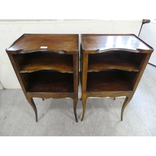 141 - A pair of late 19thC Continental stained beech bedside tables, each with two shelves, raised on cabr... 