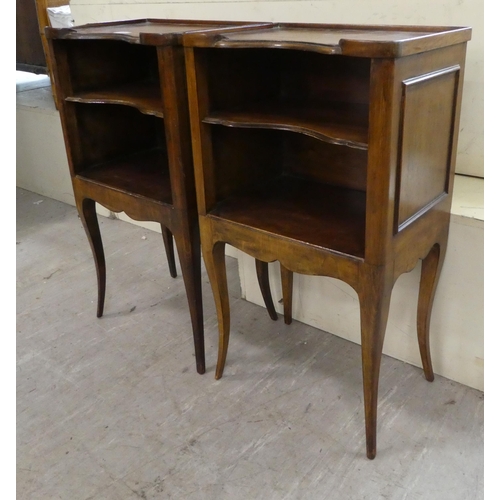 141 - A pair of late 19thC Continental stained beech bedside tables, each with two shelves, raised on cabr... 