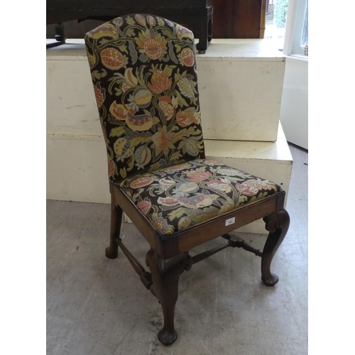 143 - A George II mahogany framed hall chair with a tapestry upholstered back and seat, raised on cabriole... 