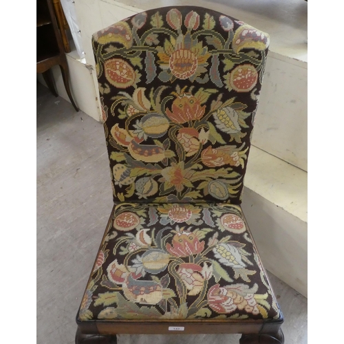 143 - A George II mahogany framed hall chair with a tapestry upholstered back and seat, raised on cabriole... 