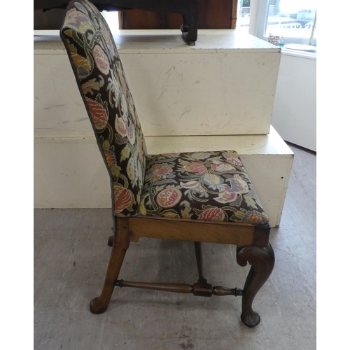 143 - A George II mahogany framed hall chair with a tapestry upholstered back and seat, raised on cabriole... 