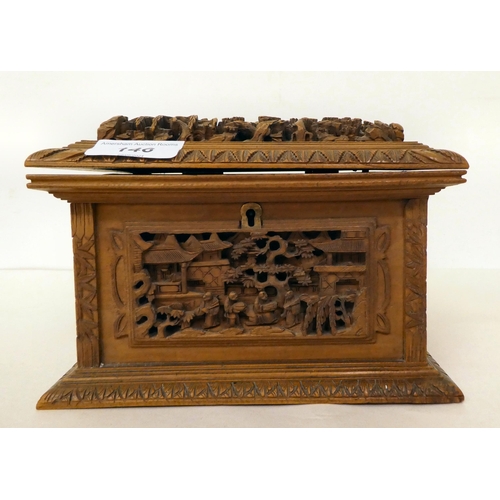 146 - A 20thC Chinese carved softwood box with straight sides and a hinged lid, decorated with a hillside ... 