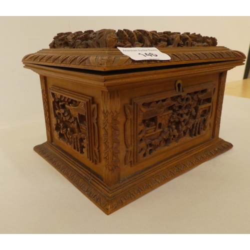 146 - A 20thC Chinese carved softwood box with straight sides and a hinged lid, decorated with a hillside ... 