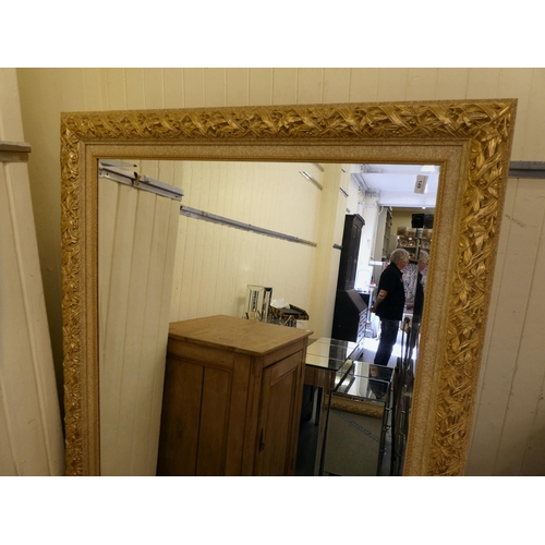 149 - A modern overmantel mirror, the bevelled plate set in a floral design gilt frame  45.5