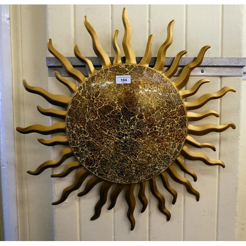 184 - A modern metal wall plaque, fashioned as a blazing sun, the centre created in mosaic glass  24