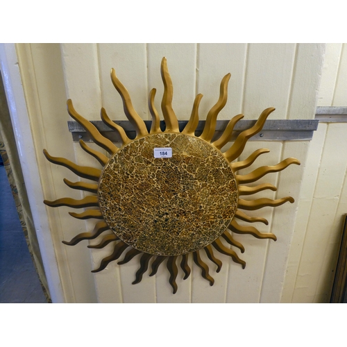 184 - A modern metal wall plaque, fashioned as a blazing sun, the centre created in mosaic glass  24