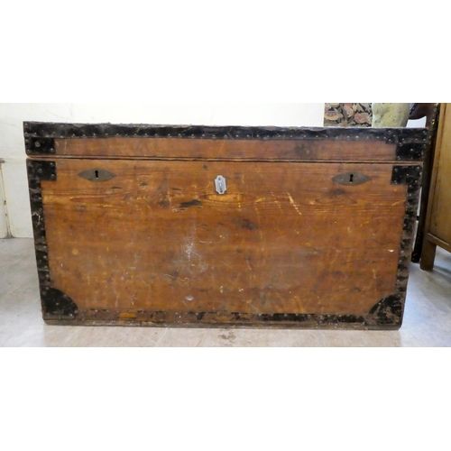 191 - A mid 20thC hardwood metal bound trunk with a hinged lid and opposing metal handles, on a plinth&nbs... 