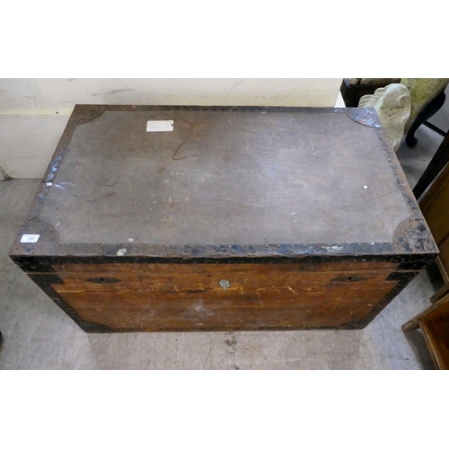 191 - A mid 20thC hardwood metal bound trunk with a hinged lid and opposing metal handles, on a plinth&nbs... 