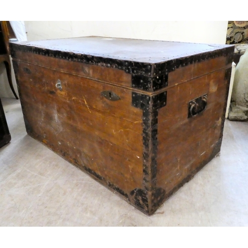 191 - A mid 20thC hardwood metal bound trunk with a hinged lid and opposing metal handles, on a plinth&nbs... 