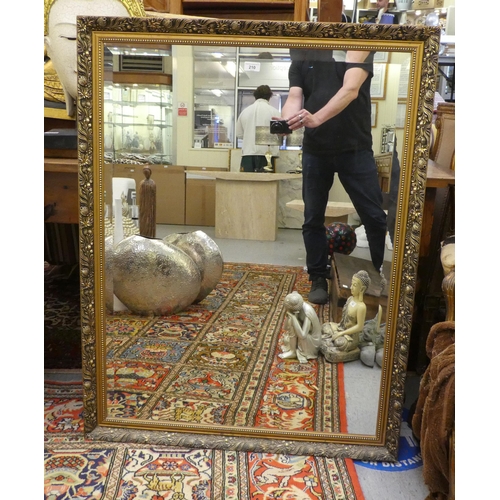 210 - A modern mirror, the bevelled plate set in a gilt frame with floral decoration  44