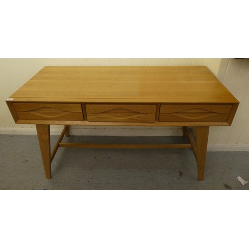 217 - A modern light oak, three drawer side table, raised on tapered legs  32