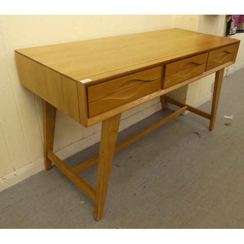 217 - A modern light oak, three drawer side table, raised on tapered legs  32