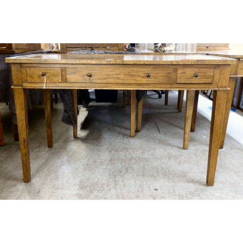 26 - A modern OKA oak desk with three drawers, raised on square, tapered legs  31