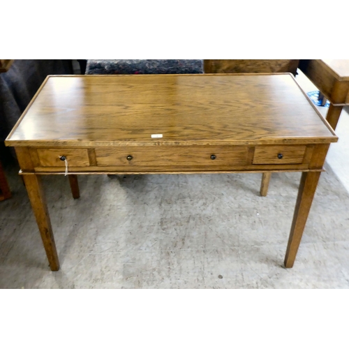 26 - A modern OKA oak desk with three drawers, raised on square, tapered legs  31