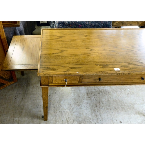 26 - A modern OKA oak desk with three drawers, raised on square, tapered legs  31