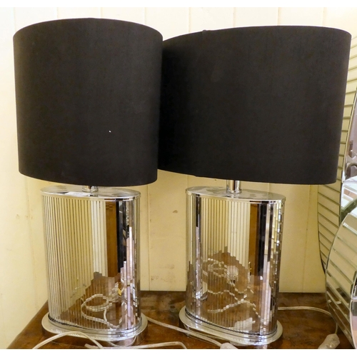 262 - A pair of modern mirrored, panelled and chromium plated lozenge design table lamps, on a plinth ... 