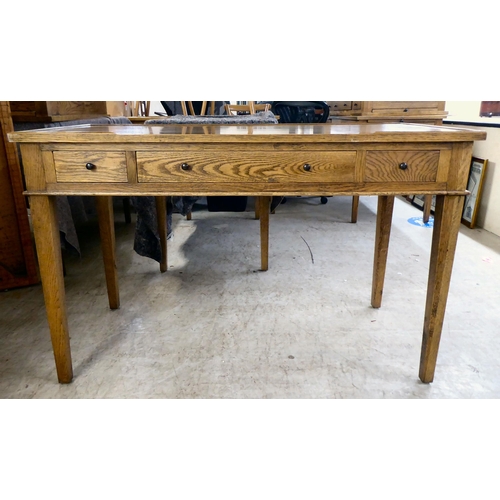 275 - A modern OKA oak desk with three drawers, raised on square, tapered legs  31