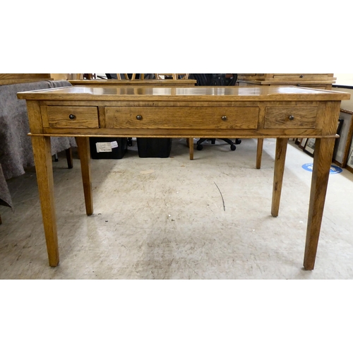 278 - A modern OKA oak desk with three drawers, raised on square, tapered legs  31