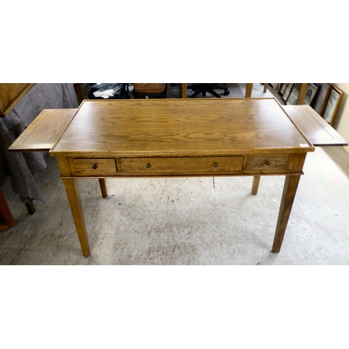 278 - A modern OKA oak desk with three drawers, raised on square, tapered legs  31