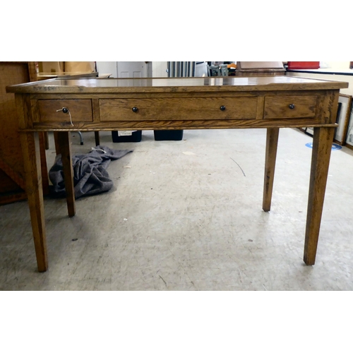 279 - A modern OKA oak desk with three drawers, raised on square, tapered legs  31