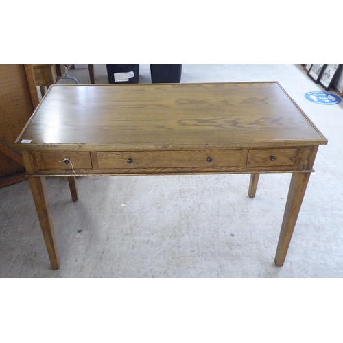 279 - A modern OKA oak desk with three drawers, raised on square, tapered legs  31