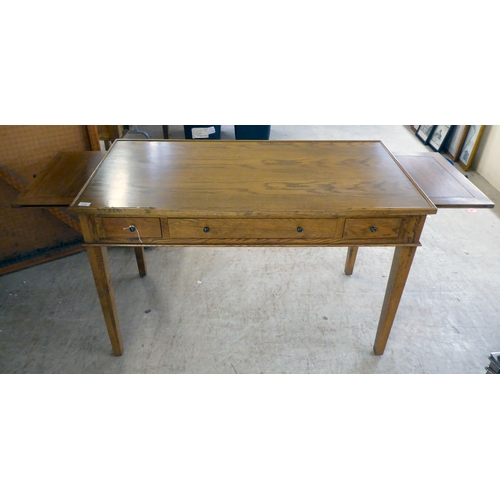 279 - A modern OKA oak desk with three drawers, raised on square, tapered legs  31