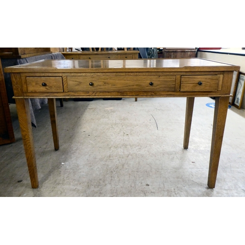 28 - A modern OKA oak desk with three drawers, raised on square, tapered legs  31