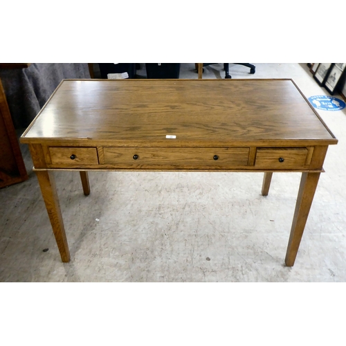 28 - A modern OKA oak desk with three drawers, raised on square, tapered legs  31