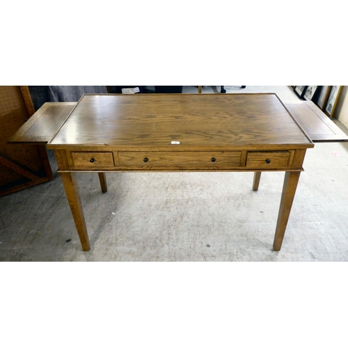 28 - A modern OKA oak desk with three drawers, raised on square, tapered legs  31