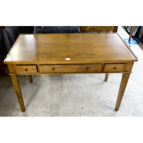 32 - A modern OKA oak desk with three drawers, raised on square, tapered legs  31