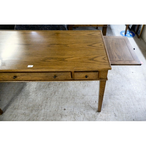 32 - A modern OKA oak desk with three drawers, raised on square, tapered legs  31