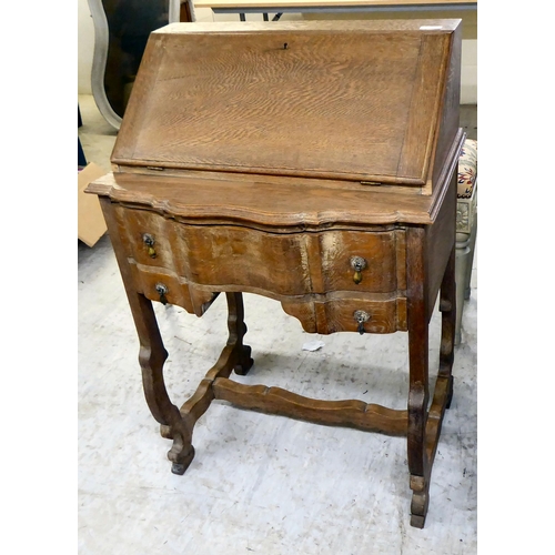 36 - A 1930s limed oak bureau with a fall flap and two drawers, raised on curved legs  37