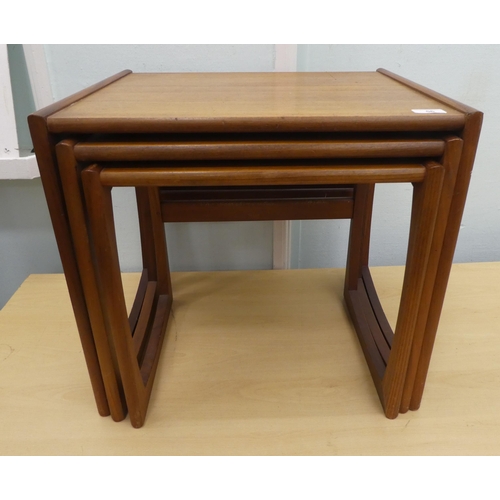 56 - A nesting set of three 20thC teak coffee tables, each raised on block legs  largest 19