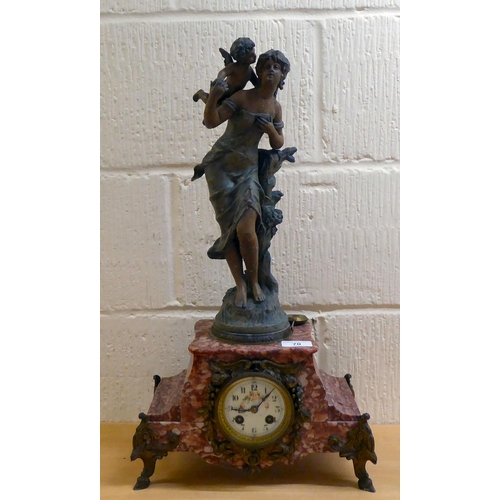 70 - A late Victorian mottled red marble mantel clock, surmounted by a spelter female figure; the 8 day m... 