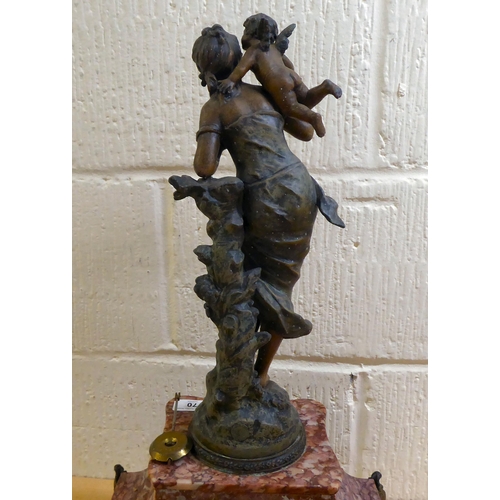 70 - A late Victorian mottled red marble mantel clock, surmounted by a spelter female figure; the 8 day m... 