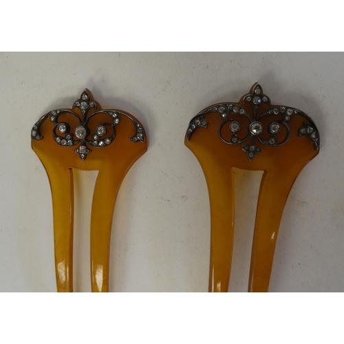 86 - A pair of early 20thC amber coloured resin hair slides, each set with diamonds