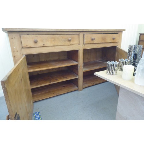 92 - A late Victorian pine dresser base with two drawers and two doors, on a plinth  36