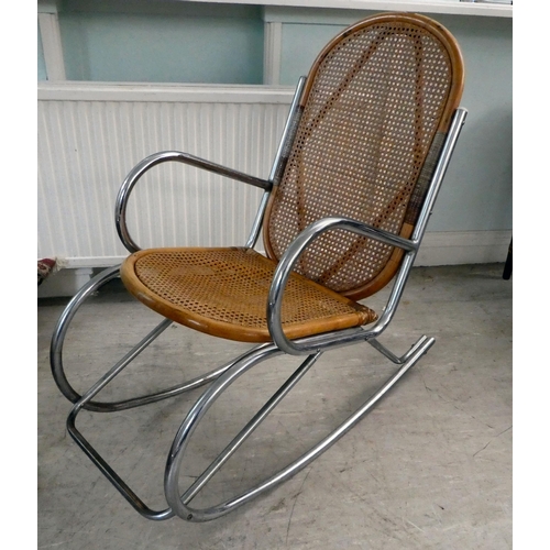 230 - A chromium plated framed rocking chair with a bamboo structure and woven cane back and seat, on a sp... 