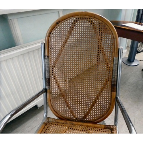 230 - A chromium plated framed rocking chair with a bamboo structure and woven cane back and seat, on a sp... 