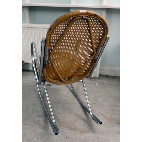 230 - A chromium plated framed rocking chair with a bamboo structure and woven cane back and seat, on a sp... 